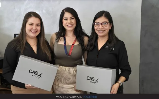 Three women holding gift boxes with the CAS and Delta logos