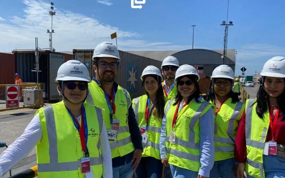 The OnBoard Peru team in hard hats and vests at the terminal, next to containers