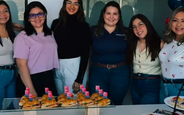 The OnBoard El Salvador team celebrates the Great Place To Work Certification by a table of snacks