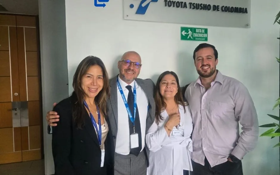 Four people smiling in front of the Toyota Tsusho de Colombia sign